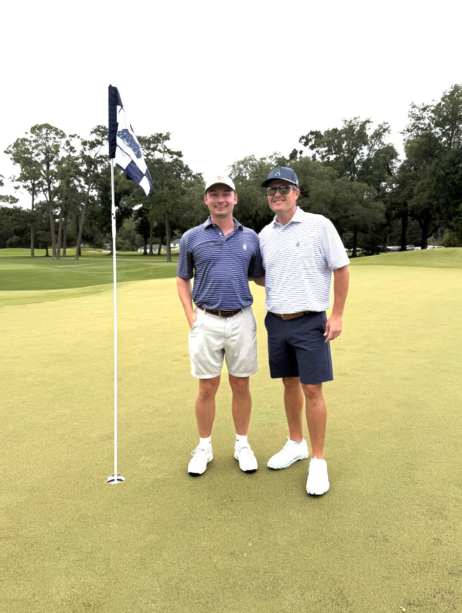 Zach Murphy and Hunter Harper standing together on the green beside the flagstick at Lakewood Golf Club