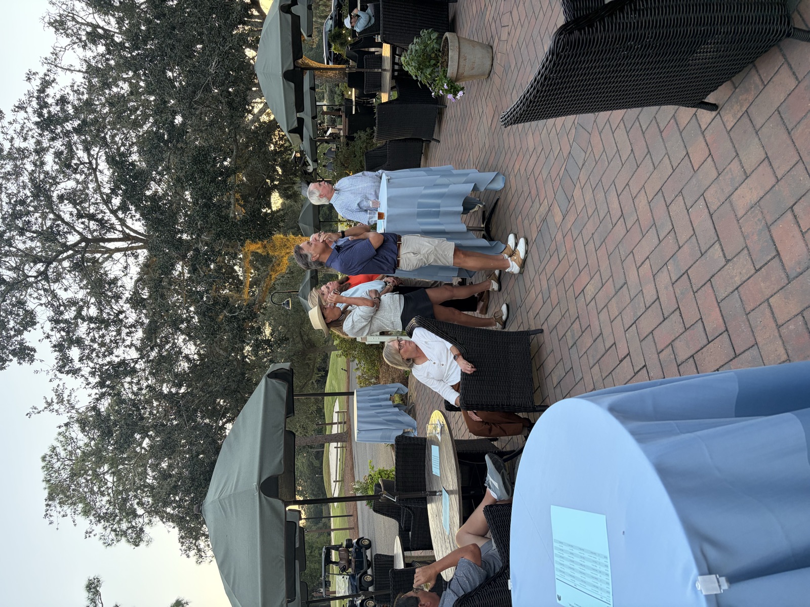 Members gathered with drinks on the clubhouse patio at sunset