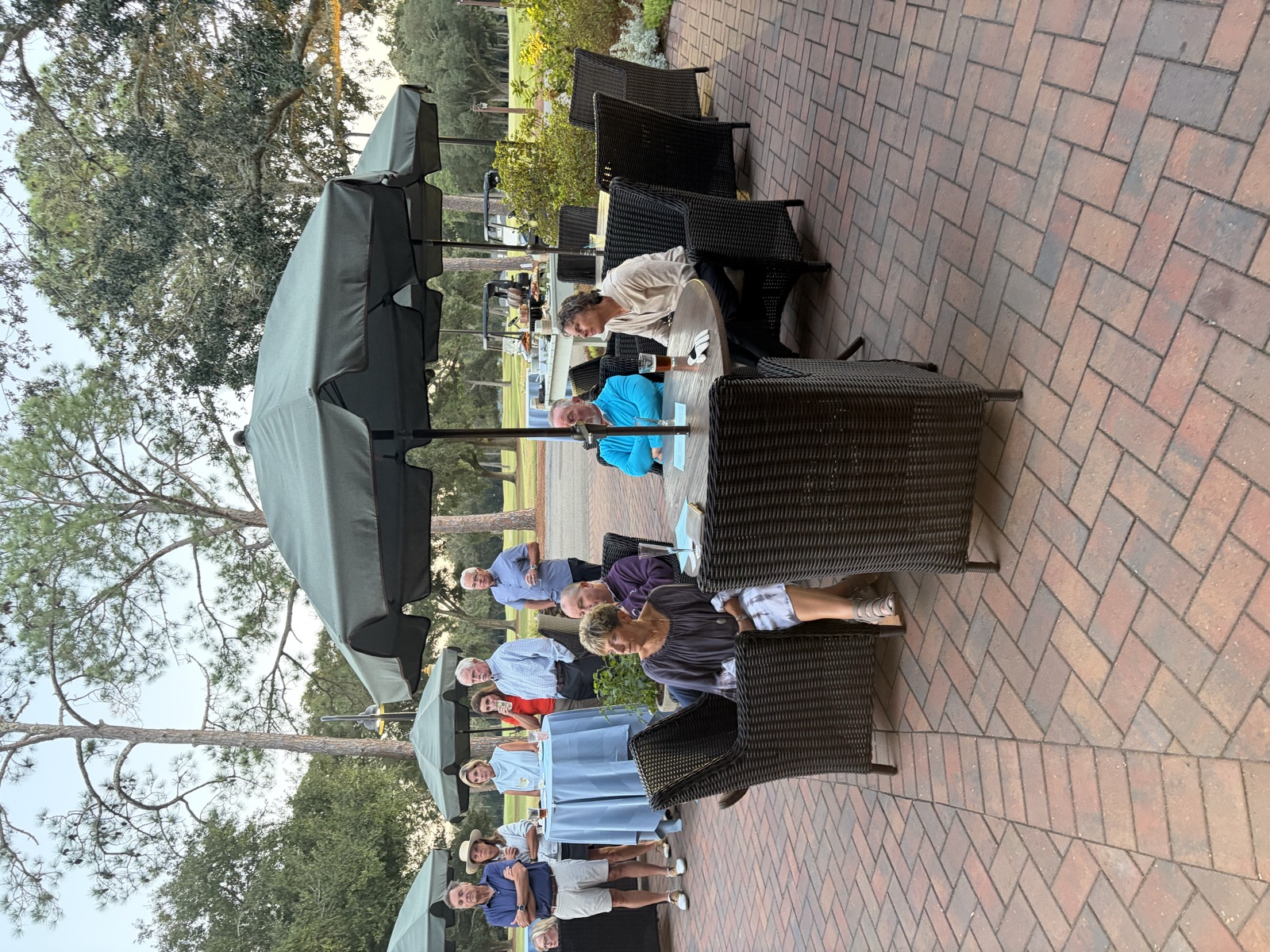 Players and guests around patio tables, with the buffet set up behind them